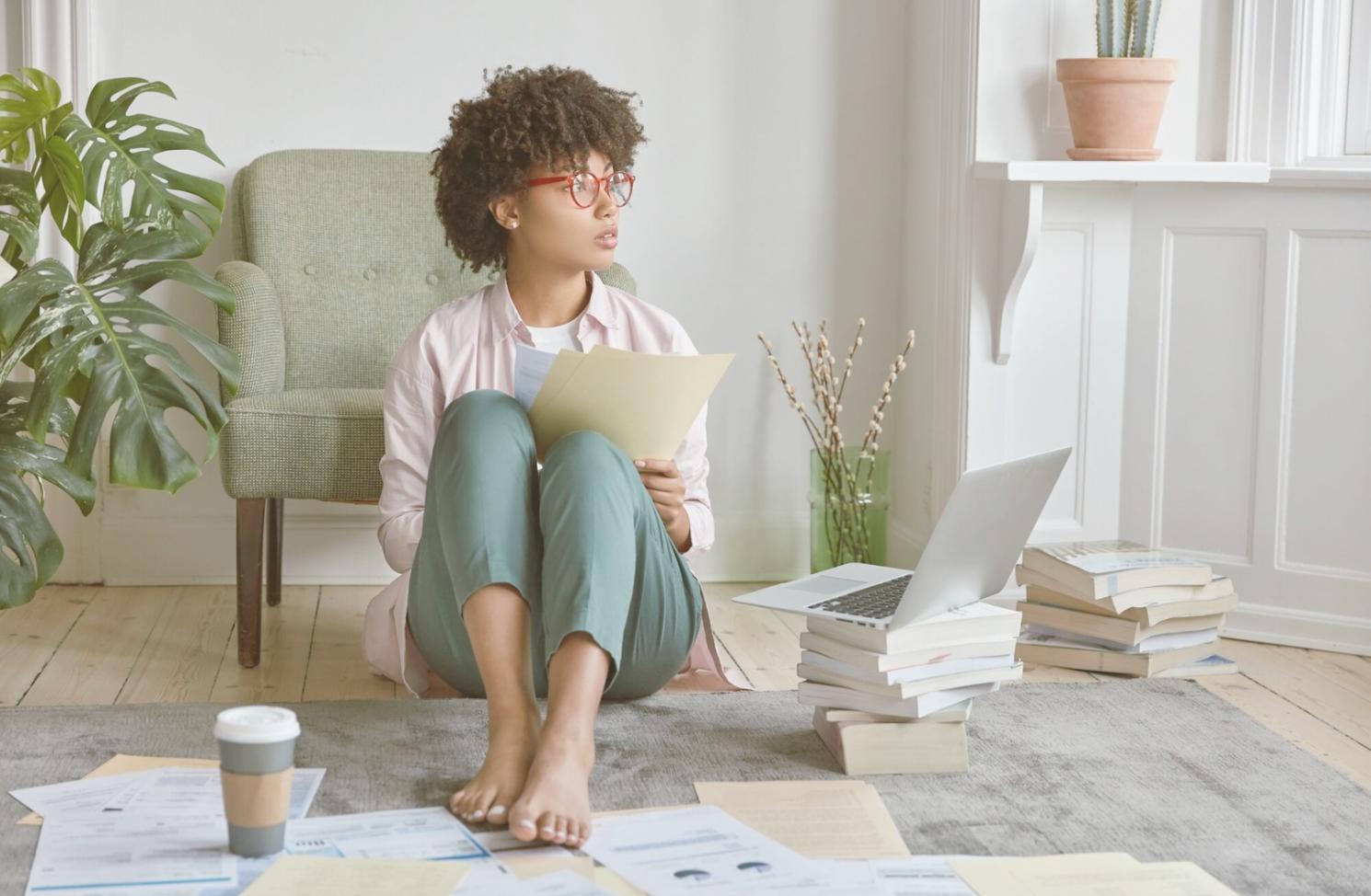 Personne analysant des documents financiers avec une calculatrice et des graphiques